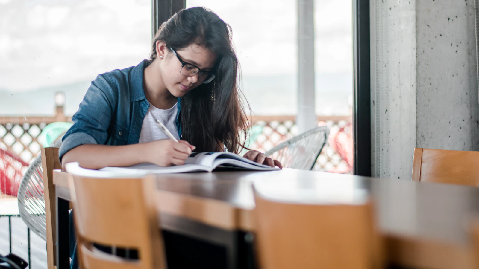 Student writing in a notebook while studying